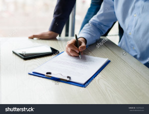 stock-photo-business-man-hands-signing-on-document-at-his-desk