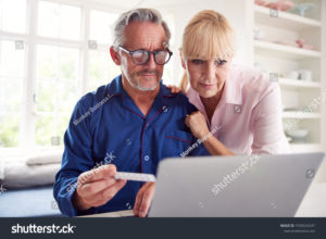 stock-photo-serious-mature-couple-at-home-looking-up-information-about-medication-online-using-laptop