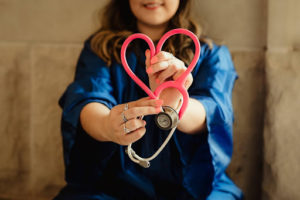  A nurse holding a stethoscope twisted into the shape of a heart
