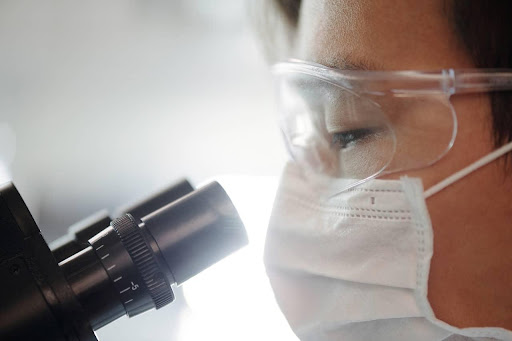 A medical researcher examining human tissue using a microscope